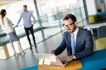 Professional handsome businessman using laptop at workplace