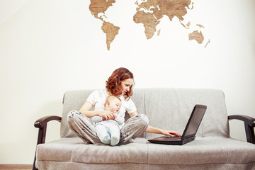 Stressfull young woman with baby and laptop at home. Working mom concept