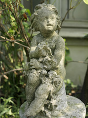 Fototapeta na wymiar old children statue profile in a garden