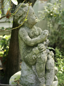 old children statue profile in a garden