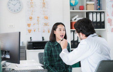 The doctor is examining the patient's oral cavity.