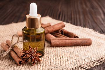 Cinnamon essential oil on a wooden background