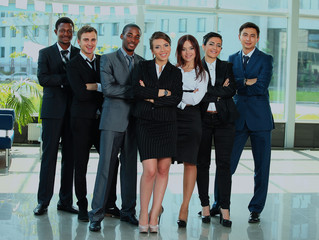 Business team in a line smiling at the camera.