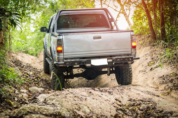 Plakat 4 wheel drive is climbing on a difficult off-road in mountain forests in Thailand.