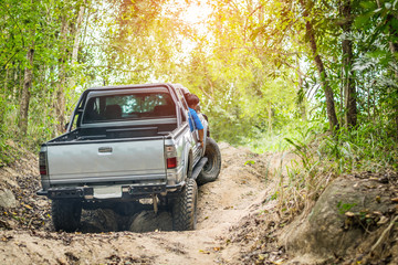 Obraz na płótnie Canvas 4 wheel drive is climbing on a difficult off-road in mountain forests in Thailand.