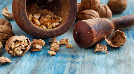 Fresh walnuts and mortar on a blue wooden table
