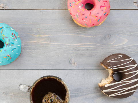 donuts and coffee on gray wooden background, copy space, top view