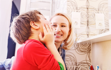 Mother and child son washing their hands and face in the bathroom