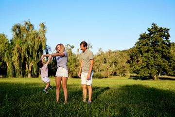 Happy family in nature. Parents with a child play in park.