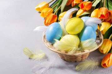 Easter eggs in basket with tulips