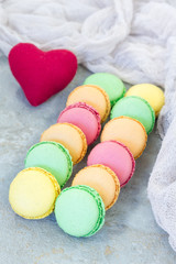 Different kinds of colorful french dessert macaron with different fillings on table, vertical