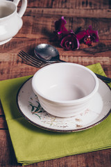 Table setting with ceramic plates, bowls, cutlery and orchid