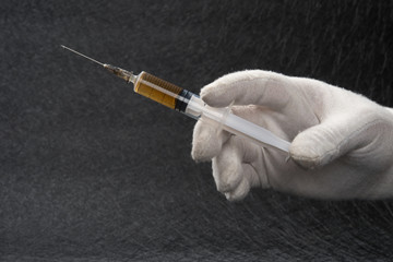 Syringe medical injection in hand with glove