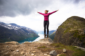 Sport couple hiking on Besseggen. Hikers enjoy beautiful lake and good weather in Norway.