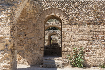 Fototapeta na wymiar The arch in the stone wall of Sandstone. Ancient masonry. The Ruins Of Carthage In Tunisia
