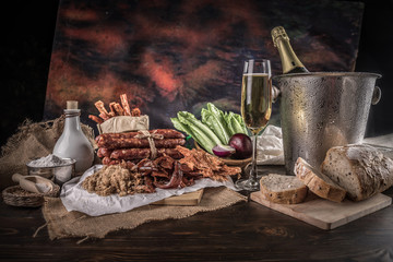 Champagne with delicious pieces of sliced ham, sausage, tomatoes, salad and vegetable - Meat platter with selection - Cutting sausage and cured meat
