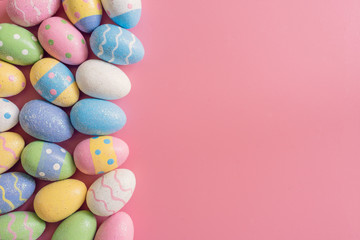 Fototapeta na wymiar Colorful easter eggs on pink pastel color background with space.