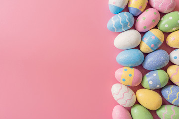 Fototapeta na wymiar Colorful easter eggs on pink pastel color background with space.