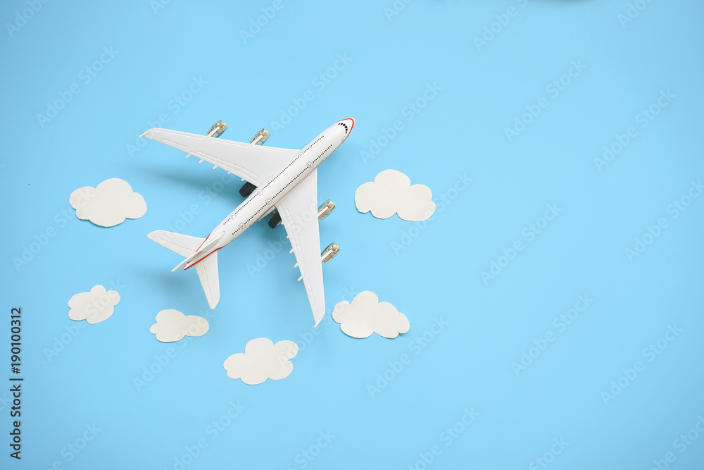 Wall mural flat lay design of travel concept with plane and cloud on blue background with copy space.