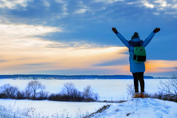 girl on the hill raised her hands, winter sunset or sunrise, a symbol of happiness and freedom_