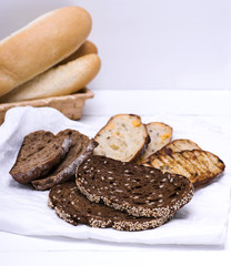 a variety of pieces of bread on a white napkin