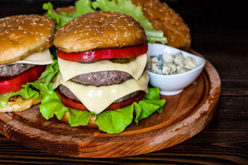 Homemade burger on wooden cutting board.