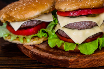 Homemade burger on wooden cutting board.