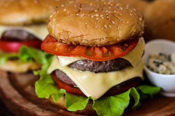 Homemade burger on wooden cutting board.