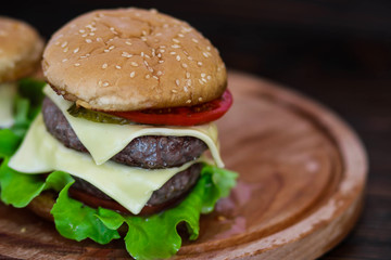 Homemade burger on wooden cutting board.