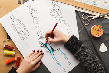 Top view on woman designer drawing clothes sketches