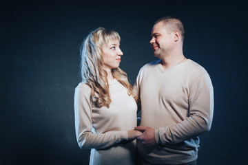 Man and woman in a white dresses lighted colored light in studio and black background