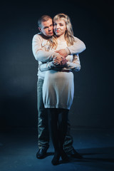 Man and woman in a white dresses lighted colored light in studio and black background