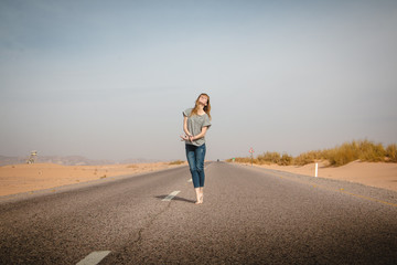 Girl have fun on the road in a desert