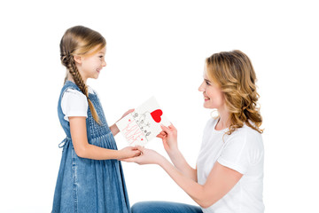 smiling daughter giving greeting card to mom, isolated on white, mothers day concept