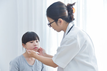 Female Doctor examining a little girl.