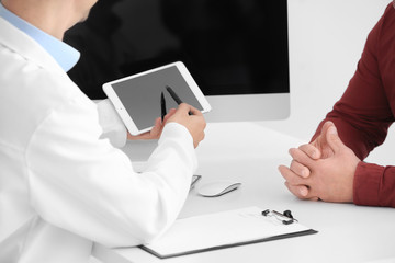Fototapeta premium Male doctor consulting patient in clinic