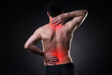 Back pain, man with backache on black background