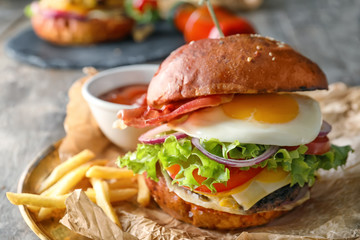 Tasty burger with fried egg on plate, closeup