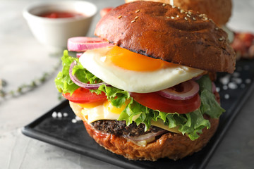 Plate with tasty burger on table, closeup
