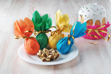 Decorated Easter eggs in white bowl and Easter cake in the background.
