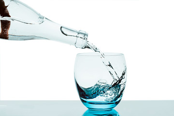 Flasche füllt leeres Glas mit Wasser