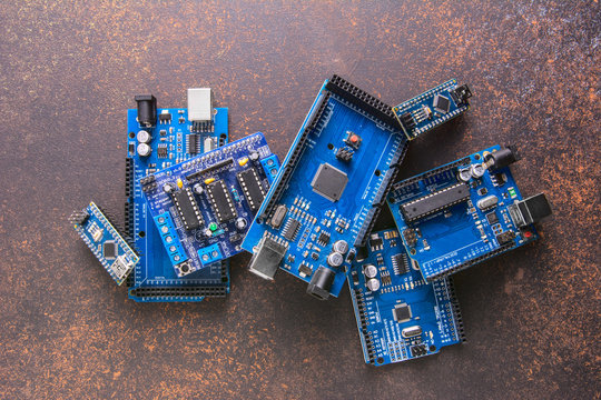 Arduino Mega, UNO, NANO board flat layout on a rusty vintage background.