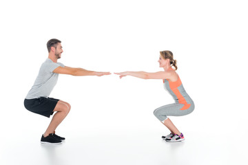 Obraz na płótnie Canvas athletic couple in sportswear doing sit ups isolated on white
