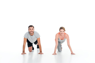 Obraz na płótnie Canvas smiling sportive couple exercising together isolated on white