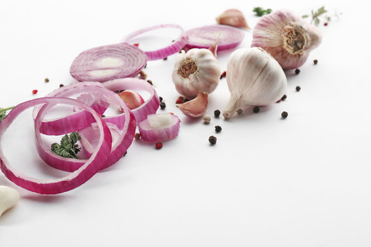 Fresh garlic, onion and pepper grains on white background