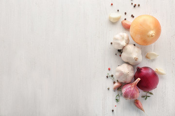 Fresh garlic, onion and pepper grains on light background, top view