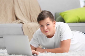 Teenage boy with laptop at home