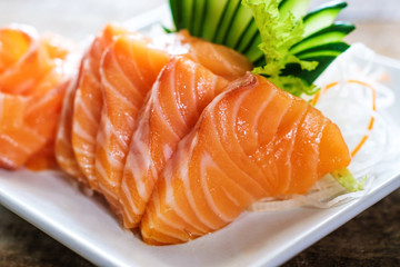 Sashimi, Salmon, Japanese food chopsticks and wasabi on the wood table
