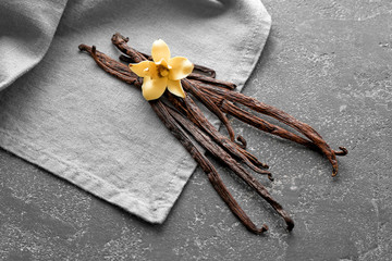 Vanilla sticks and flower on grey table