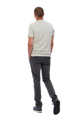 Back view of going  handsome man. walking young guy . Rear view people collection.  backside view of person.  Isolated over white background. A guy in a white T-shirt and trousers leaves the frame.